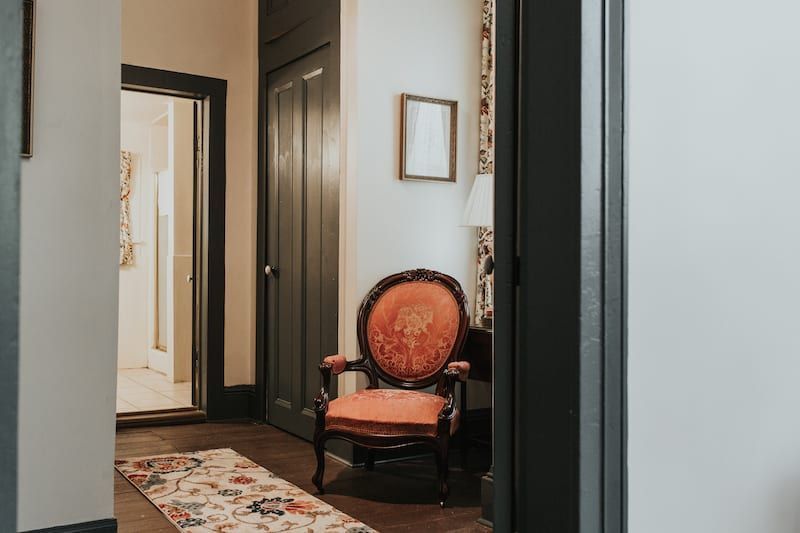 A chair is sitting in a hallway next to a door.