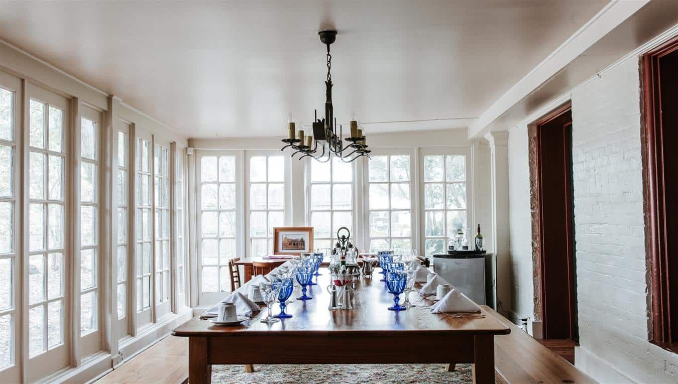 A large dining room with a long table and a chandelier.