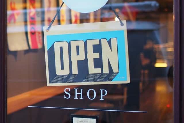 An open shop sign hangs in a store window