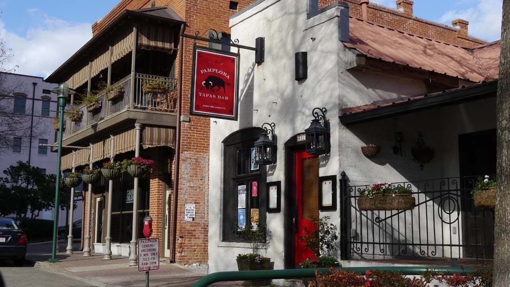 A white building with a red sign on the side of it.