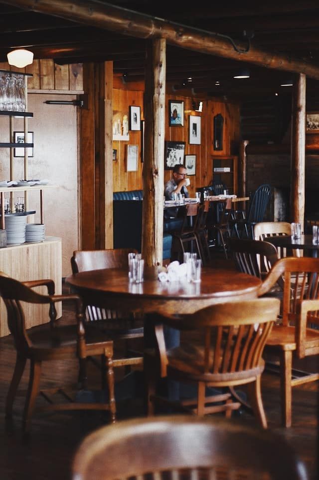 A man is sitting at a table in a restaurant.