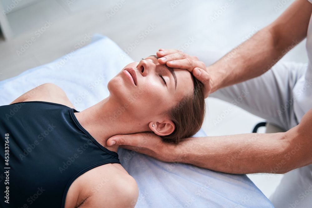 Eine Frau bekommt einen Kopfmassage von einem Mann .