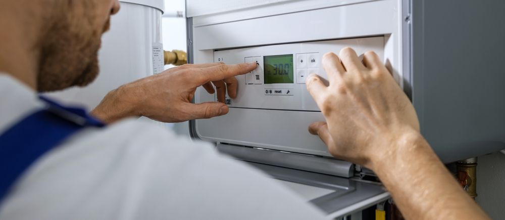 Person's hands adjusting the control panel on a white appliance.
