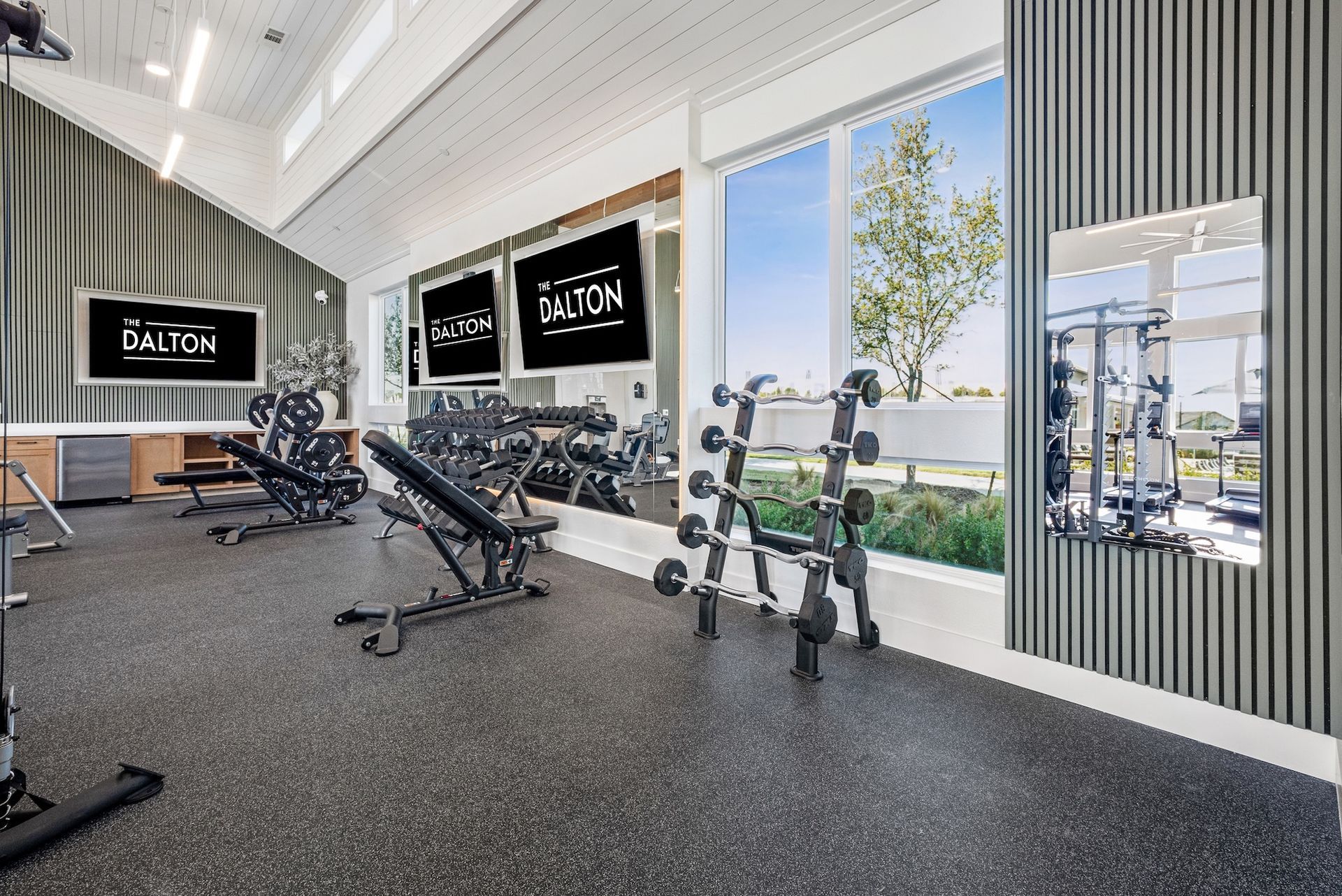Gym with exercise equipment, large windows, mirrors, and the