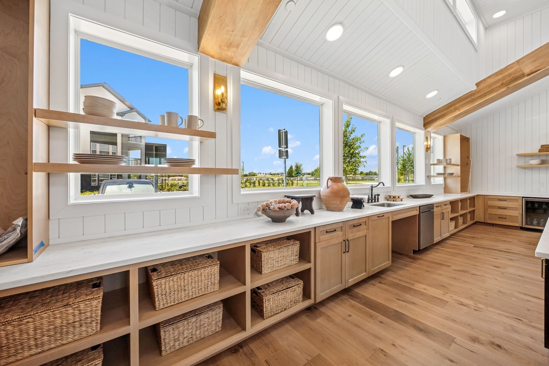 A kitchen with a lot of shelves and a lot of windows.
