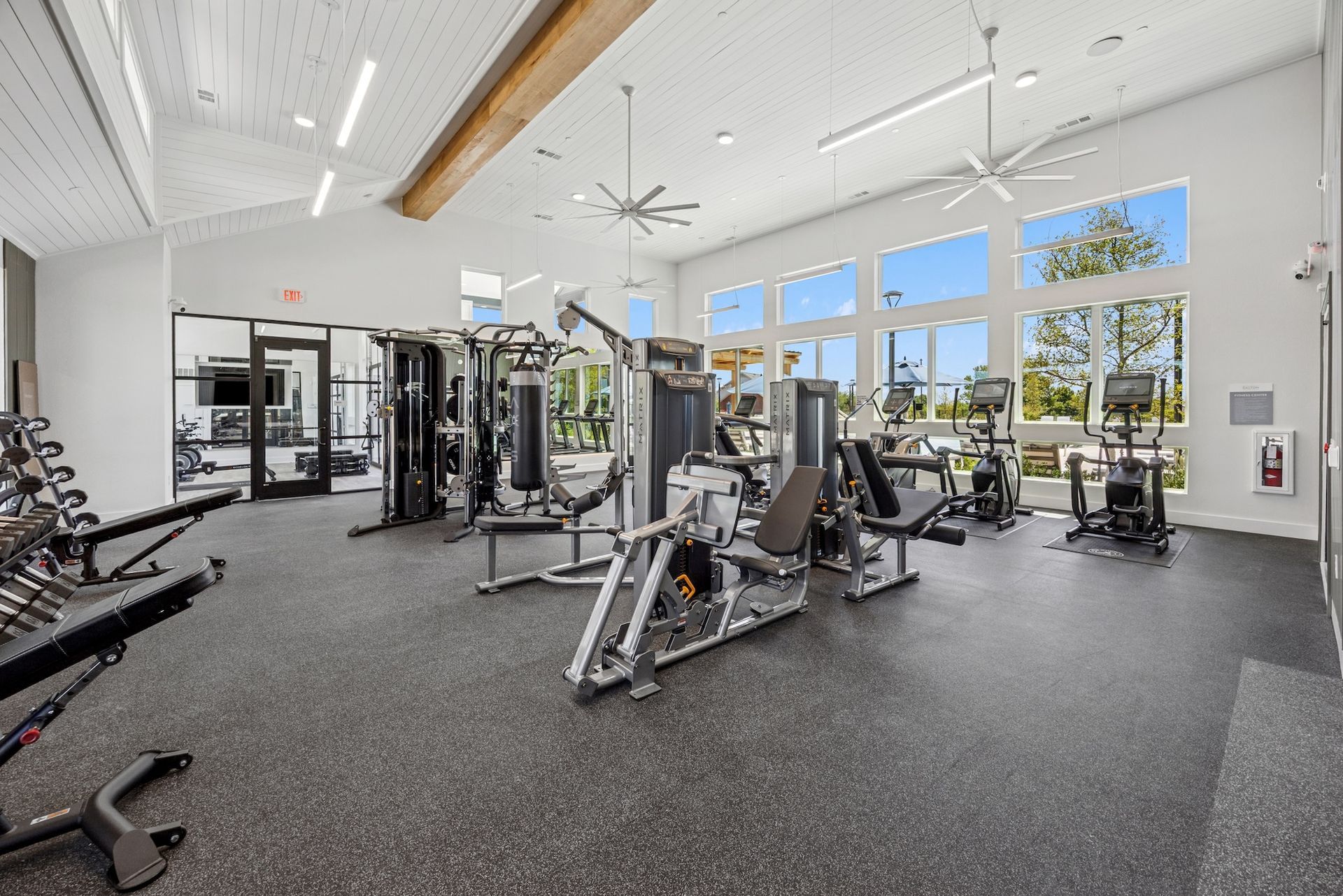 A large gym filled with lots of exercise equipment.