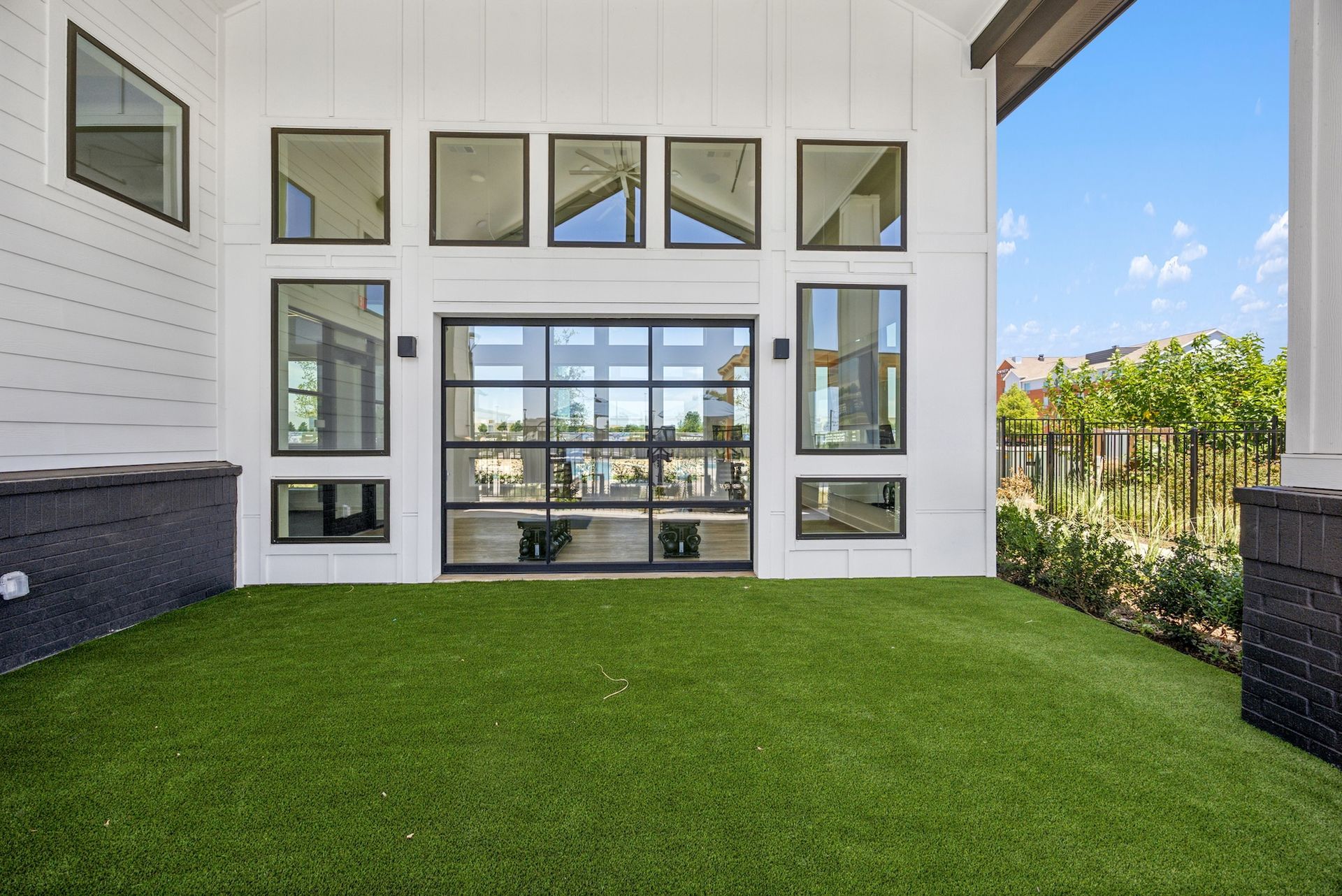 A large white house with a lot of windows and a large lawn in front of it.