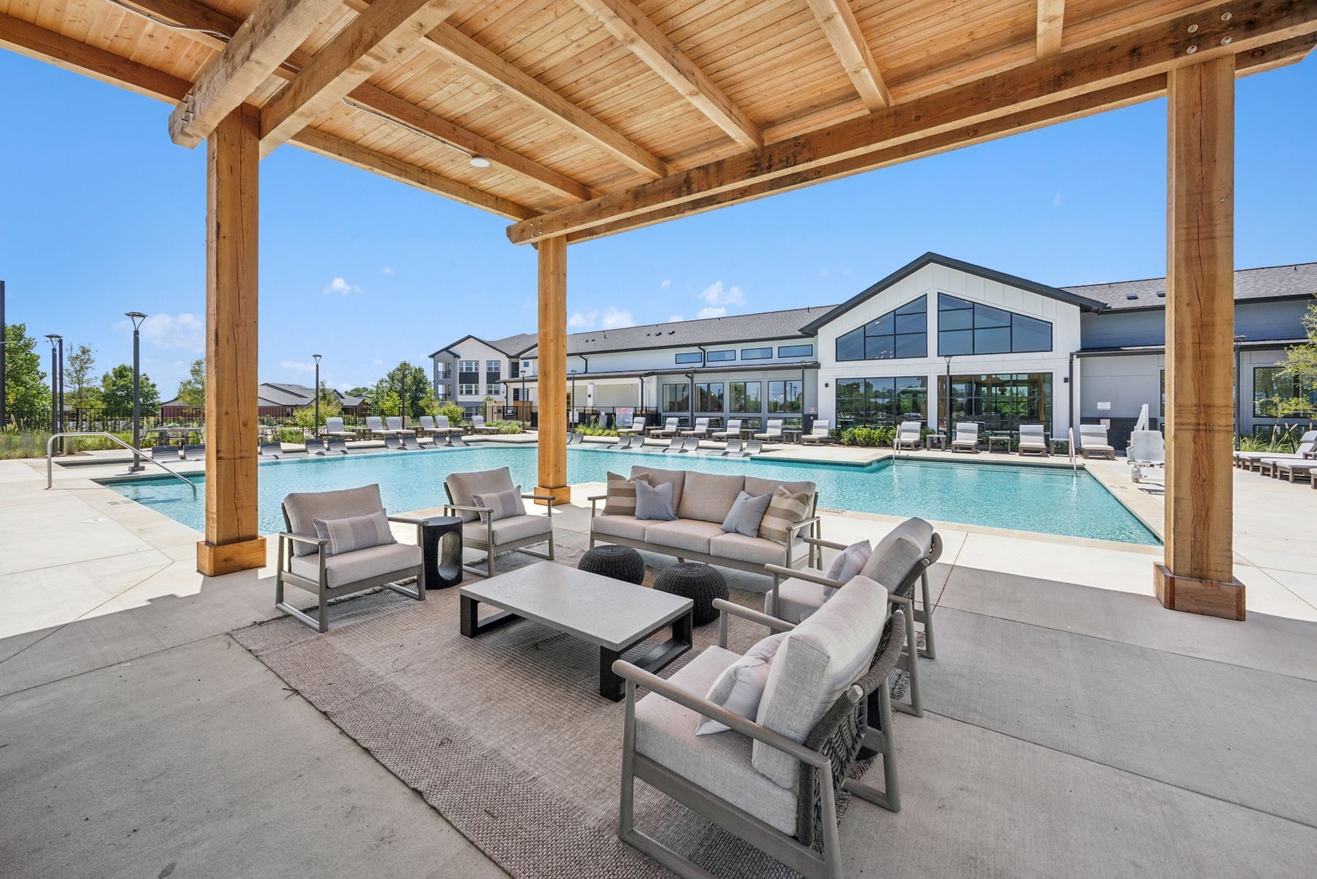 Outdoor patio seating area overlooking a pool on a sunny day.