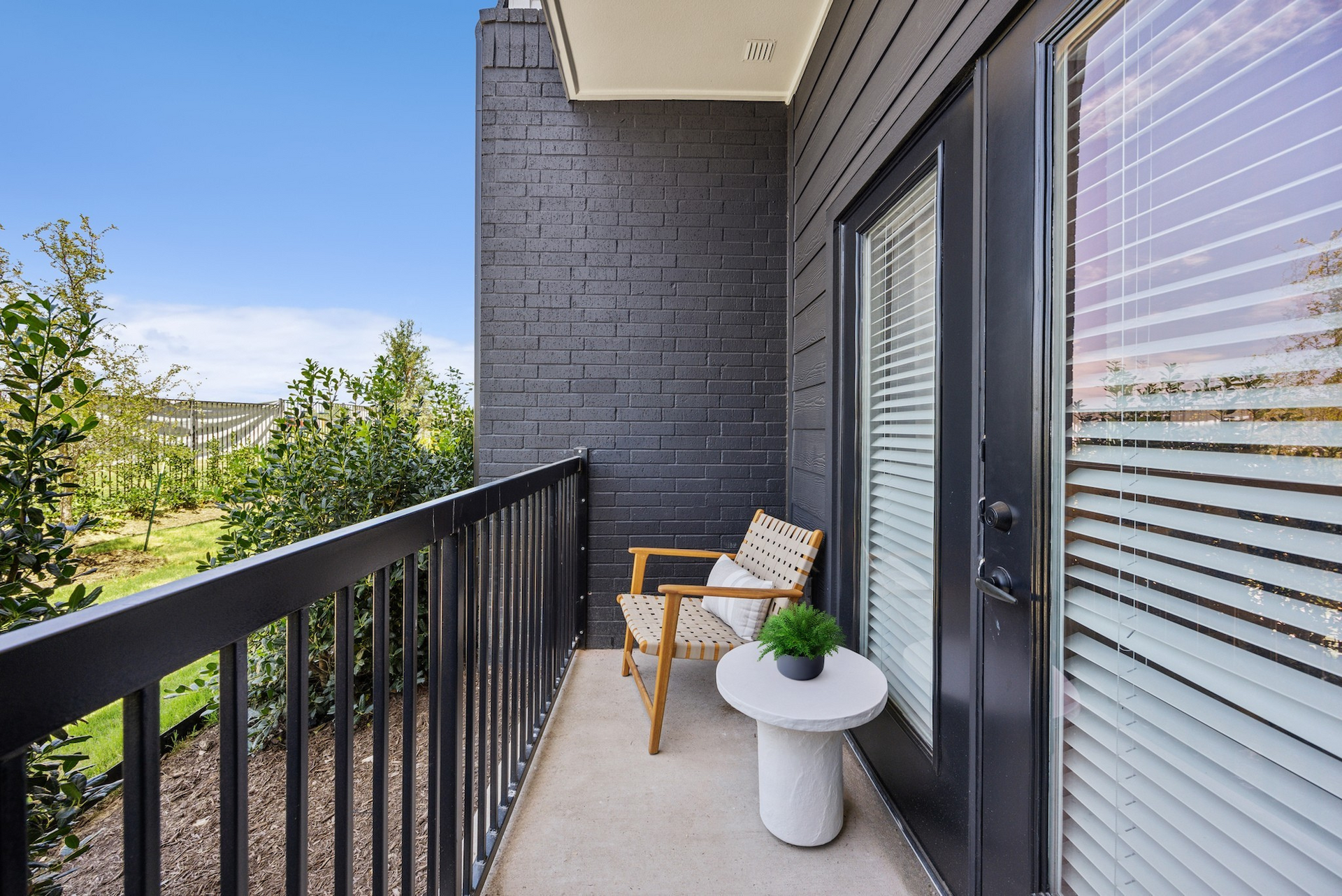 There is a balcony with a chair and a table on it.