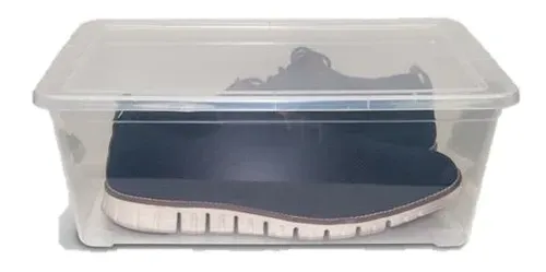 Caja de almacenamiento de plástico transparente que contiene un par de zapatillas negras con suelas blancas.