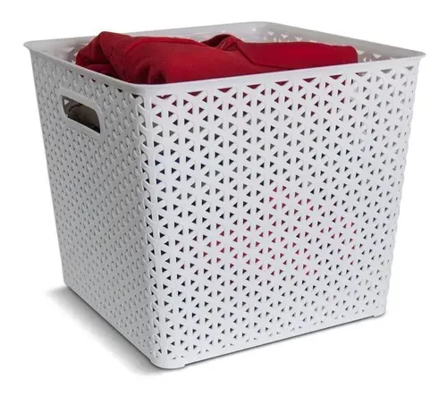 Cesto de ropa blanco perforado con ropa roja en su interior.