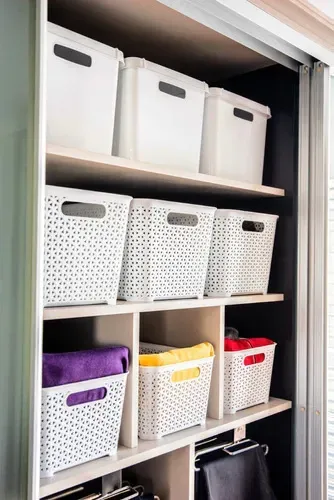 Cesta de almacenamiento de plástico blanco con tapa y diseño tejido.