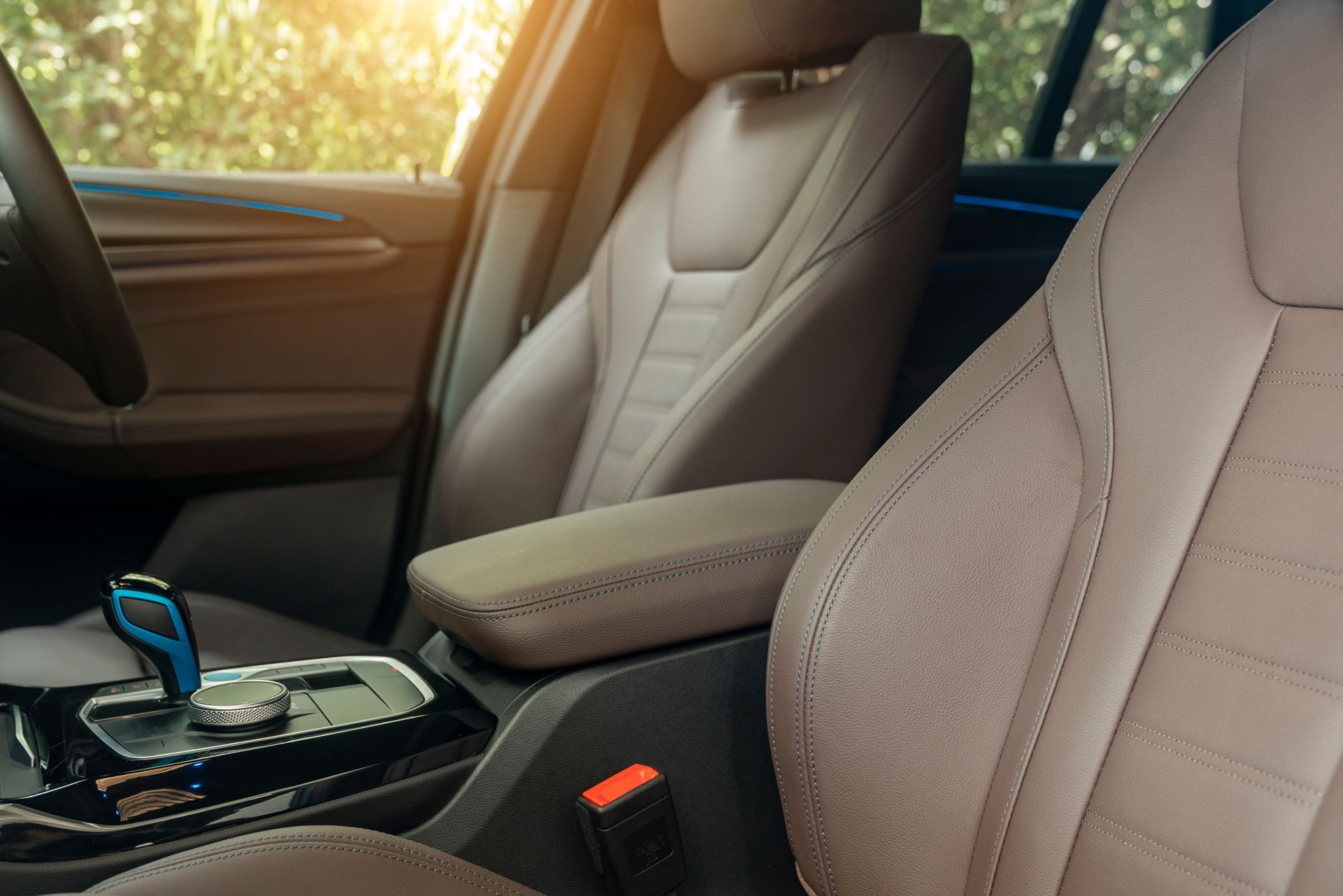The inside of an Audi car, showing the beige seats, car doors, and space between the front seats.