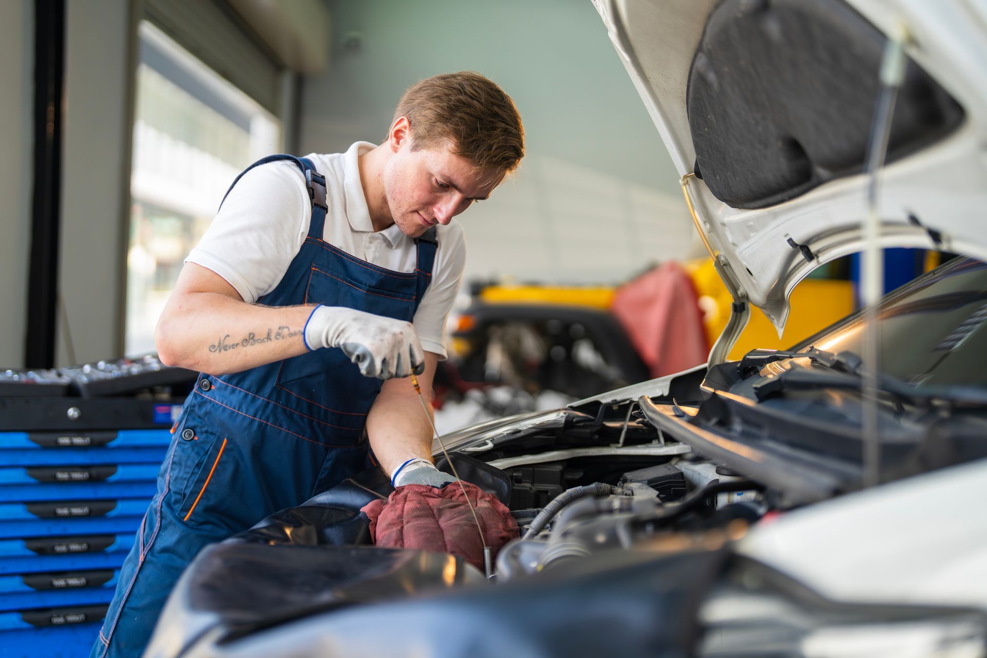 A mechanic is providing maintenance to a car. A mechanic is providing maintenance to a car.