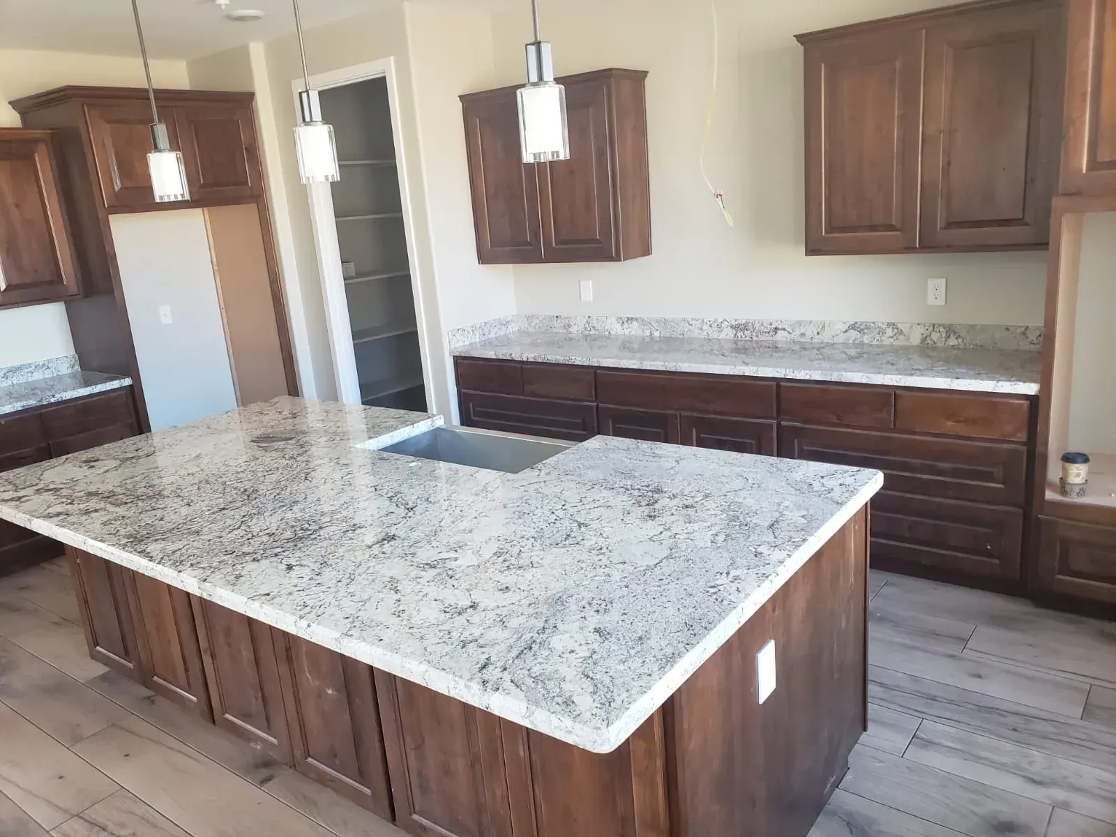 Kitchen with brown cabinets, granite countertops, and a central island.
