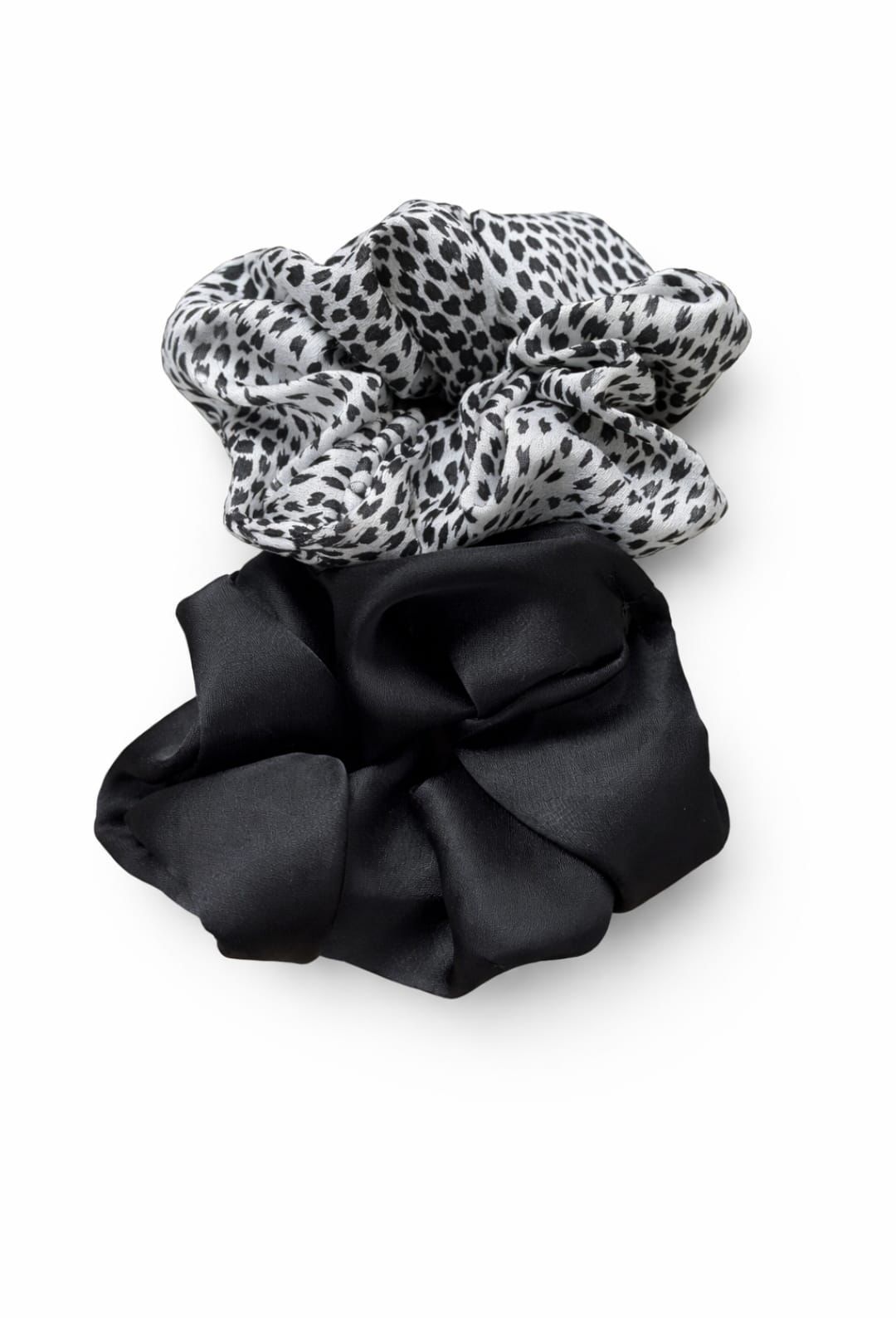 Dos coleteros: uno blanco con lunares negros y otro negro con lunares blancos, sobre un fondo blanco.