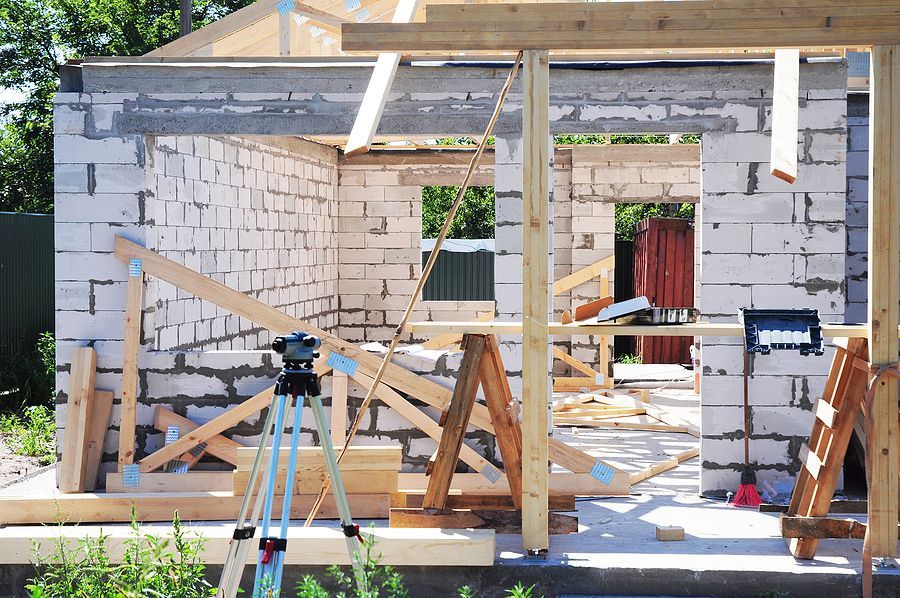 a house under construction with a camera on a tripod