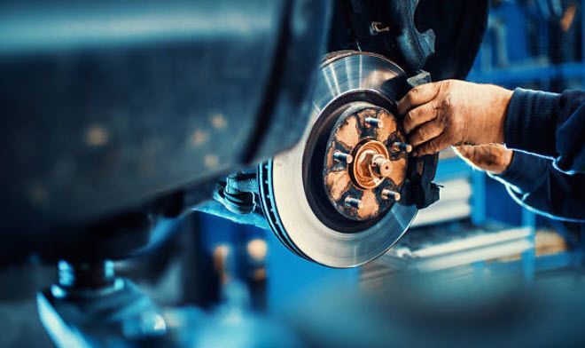 Mechanic performing brake service on a vehicle rotor at PROFIX Auto Repair in Norman OK