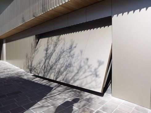 Un edificio con l'ombra di un albero su un lato.