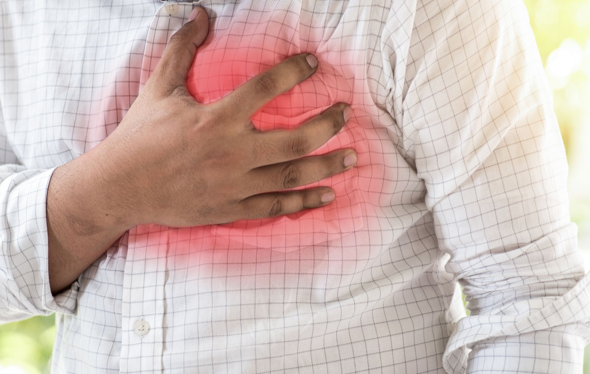 A Man Is Holding His Chest In Pain Because He Has A Heart Attack — Chicago, IL — Chicagoland Home Physicians