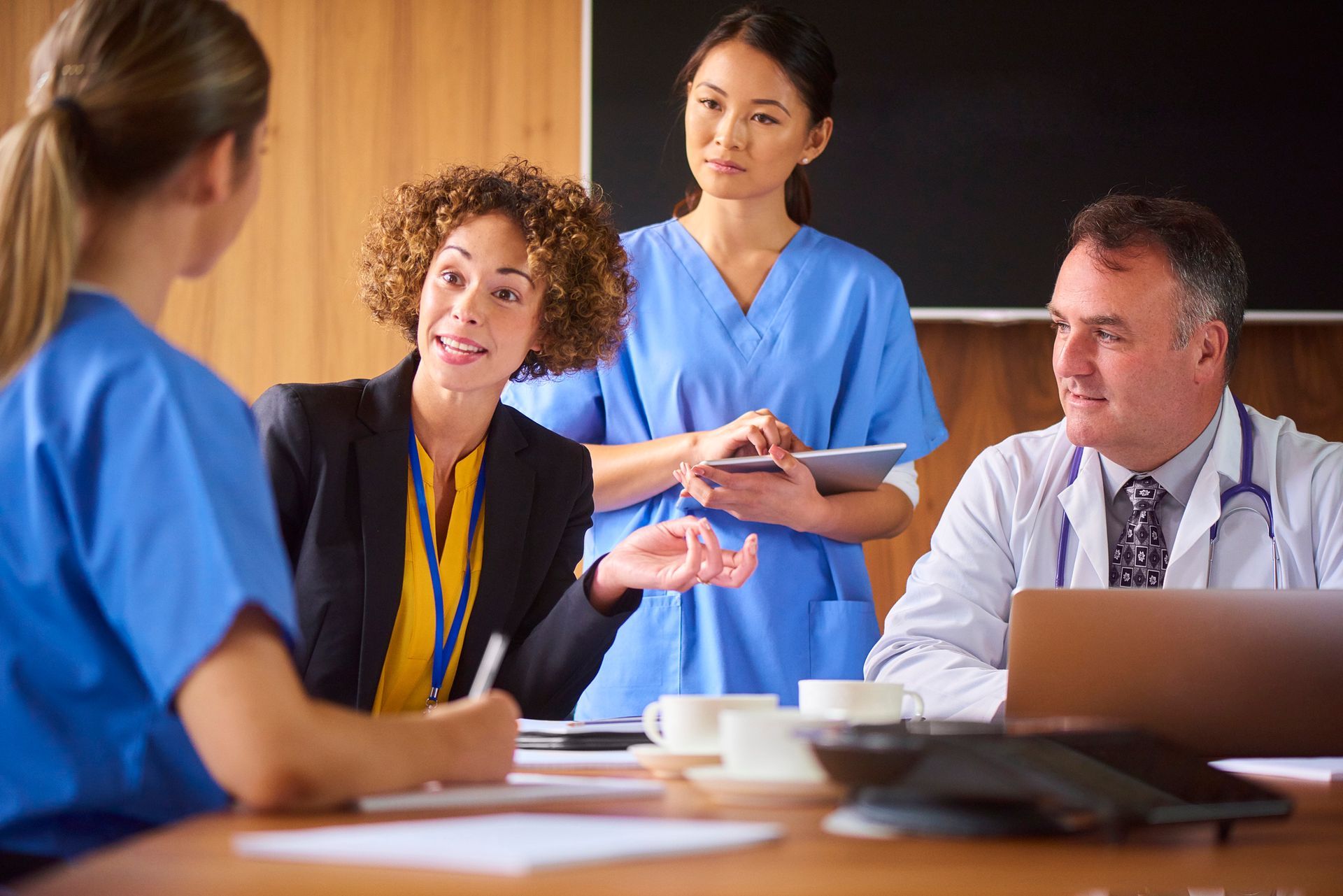 A Group Of Doctors And Nurses Are Having A Meeting In A Conference Room — Chicago, IL — Chicagoland Home Physicians