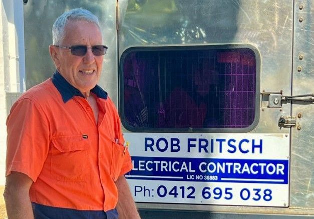 A Man is Working on a Stove in a Kitchen — Rob Fritsch Electrical in Wagga Wagga, NSW