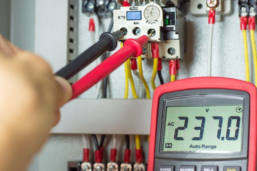 A Person is Using a Multimeter to Test a Circuit Board — Rob Fritsch Electrical in Wagga Wagga, NSW