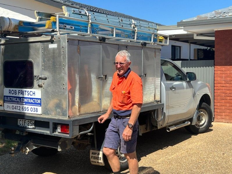 A Man is Standing in Front of a Rob Fritsch Electrical Contractor Van — Rob Fritsch Electrical in Wagga Wagga, NSW