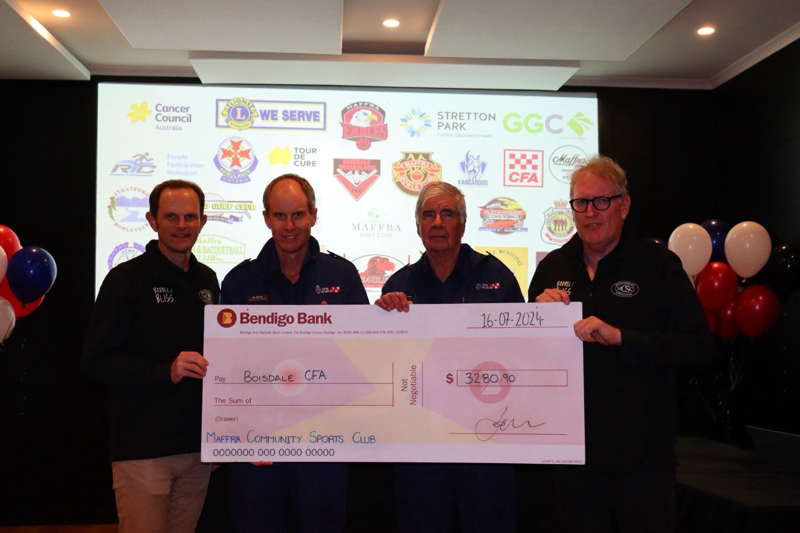 Four men holding a large check for the 