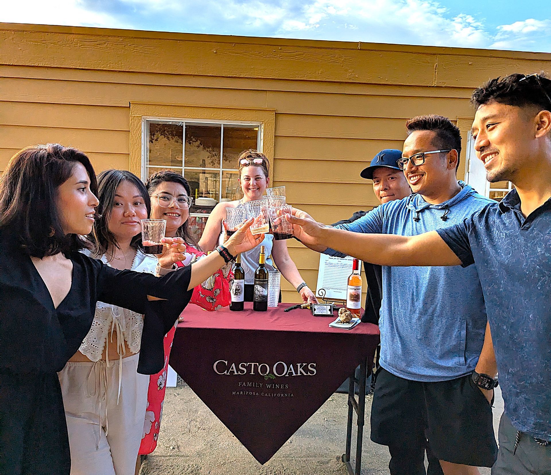 A group of people are standing around a table with casto oaks on it.