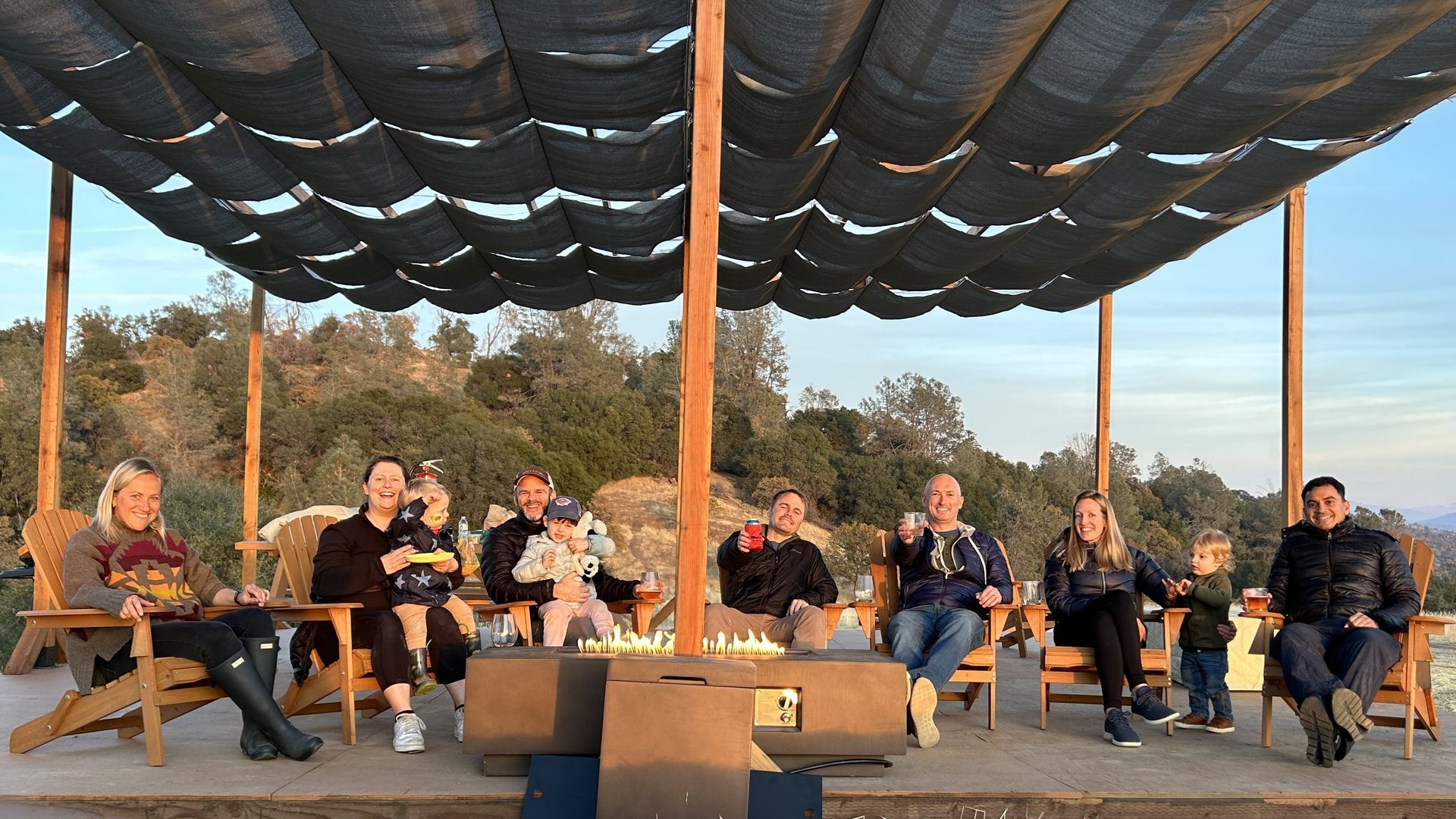 A group of people are sitting in chairs under a canopy.
