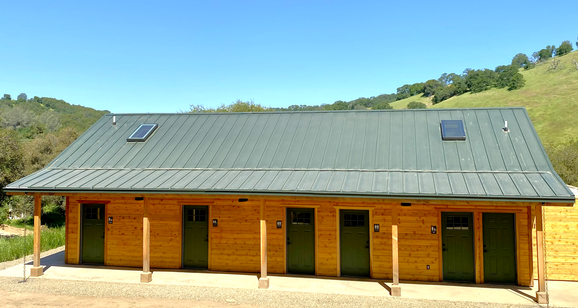 A wooden house with a green roof and green doors