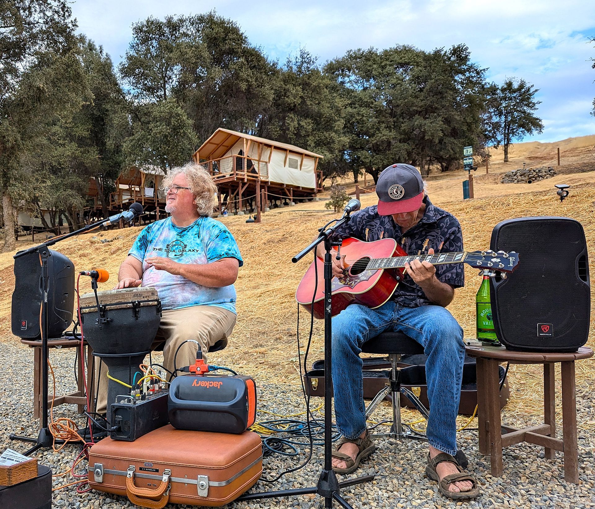 A man is playing a guitar and a woman is playing drums.