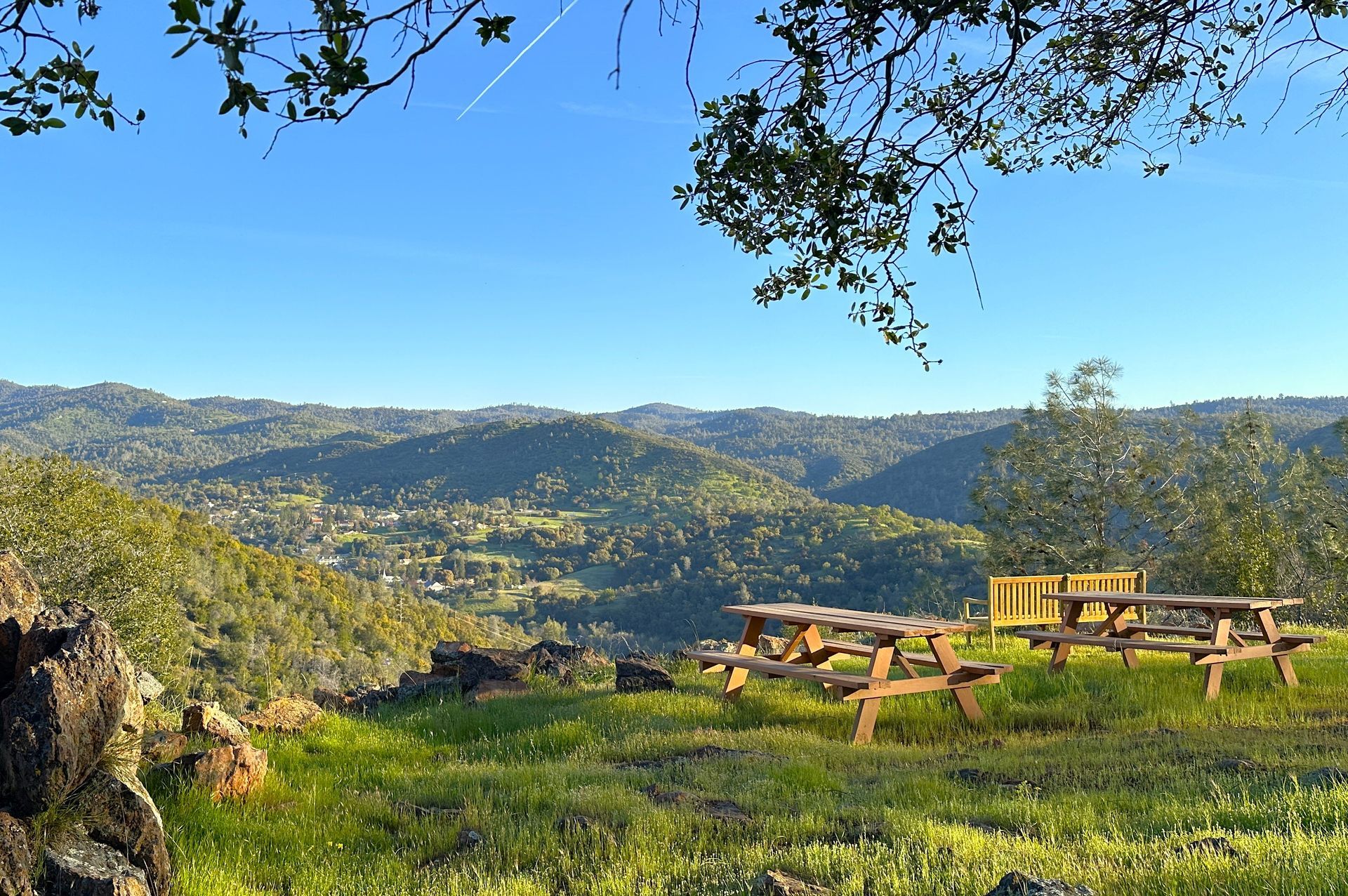 A group of picnic tables on top of a hill overlooking a valley