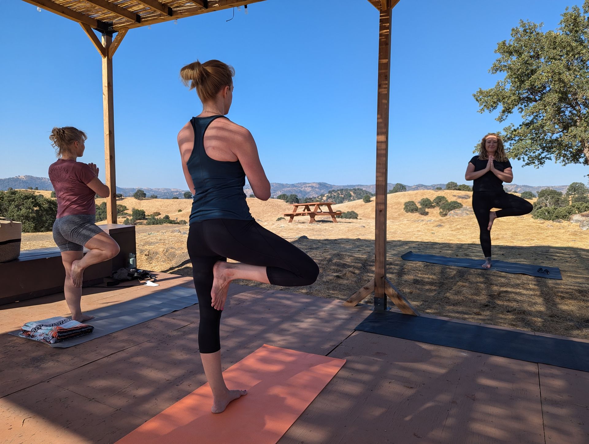 A group of women are practicing yoga on a patio.