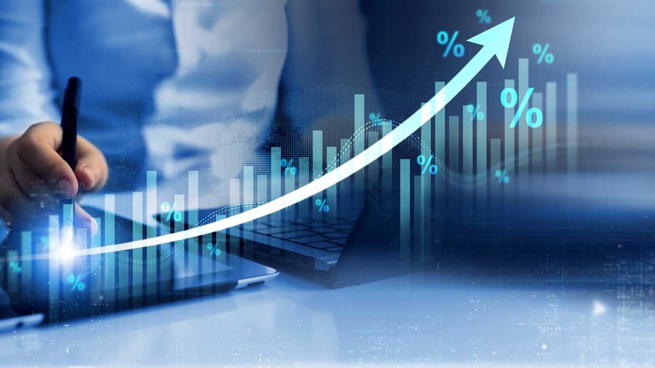 Person using a tablet with a pen, overlaid with a rising graph and percentage symbols.