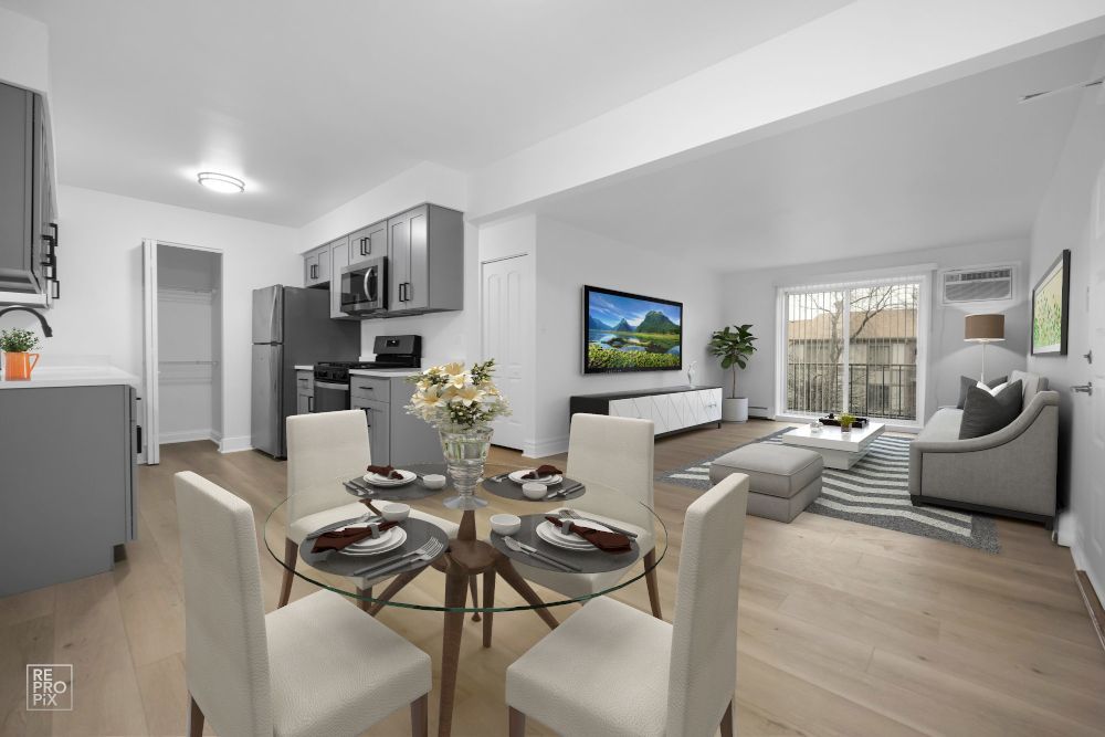 A living room with a dining table and chairs and a kitchen.