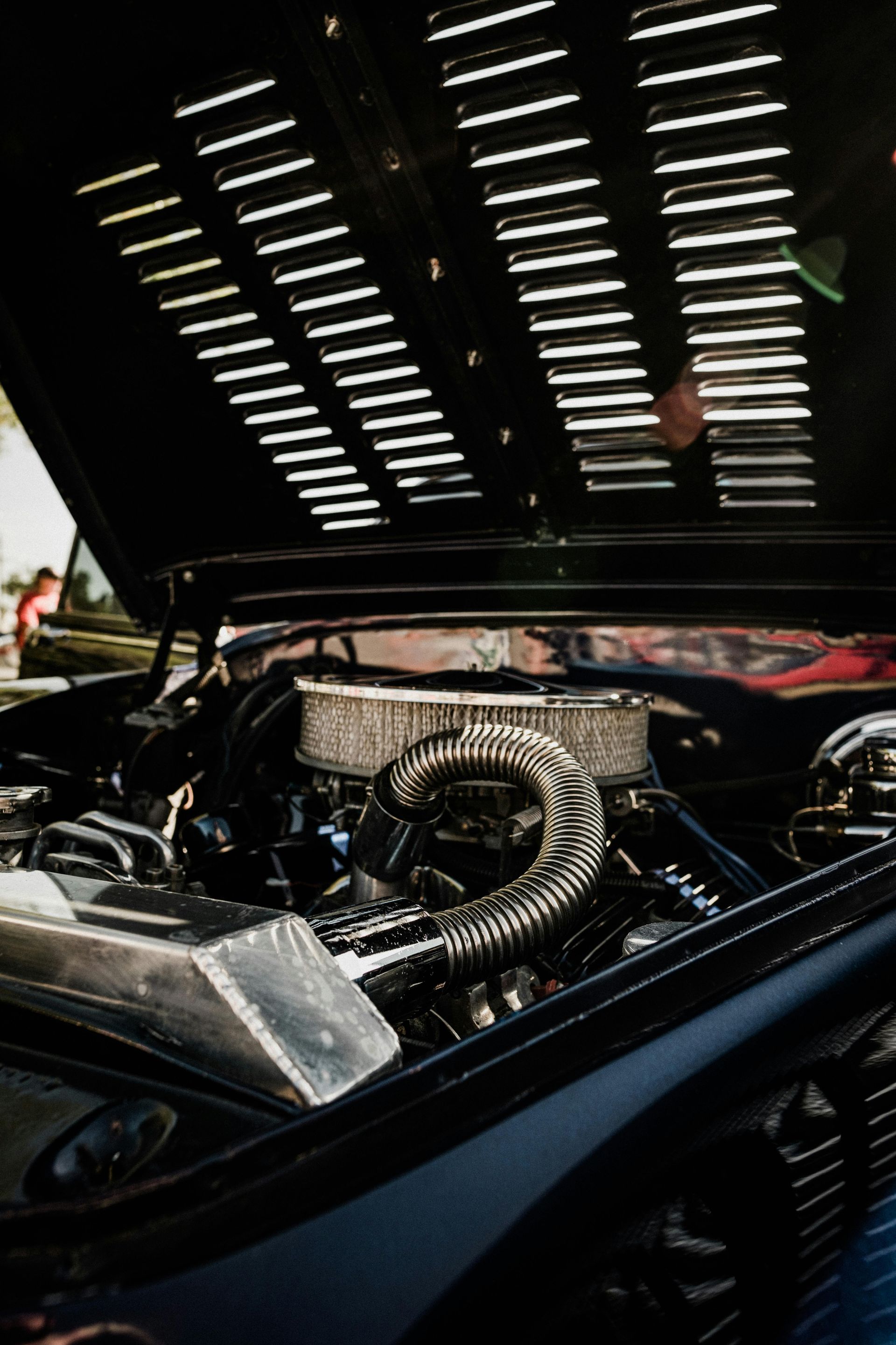 A close up of a car engine with the hood open.