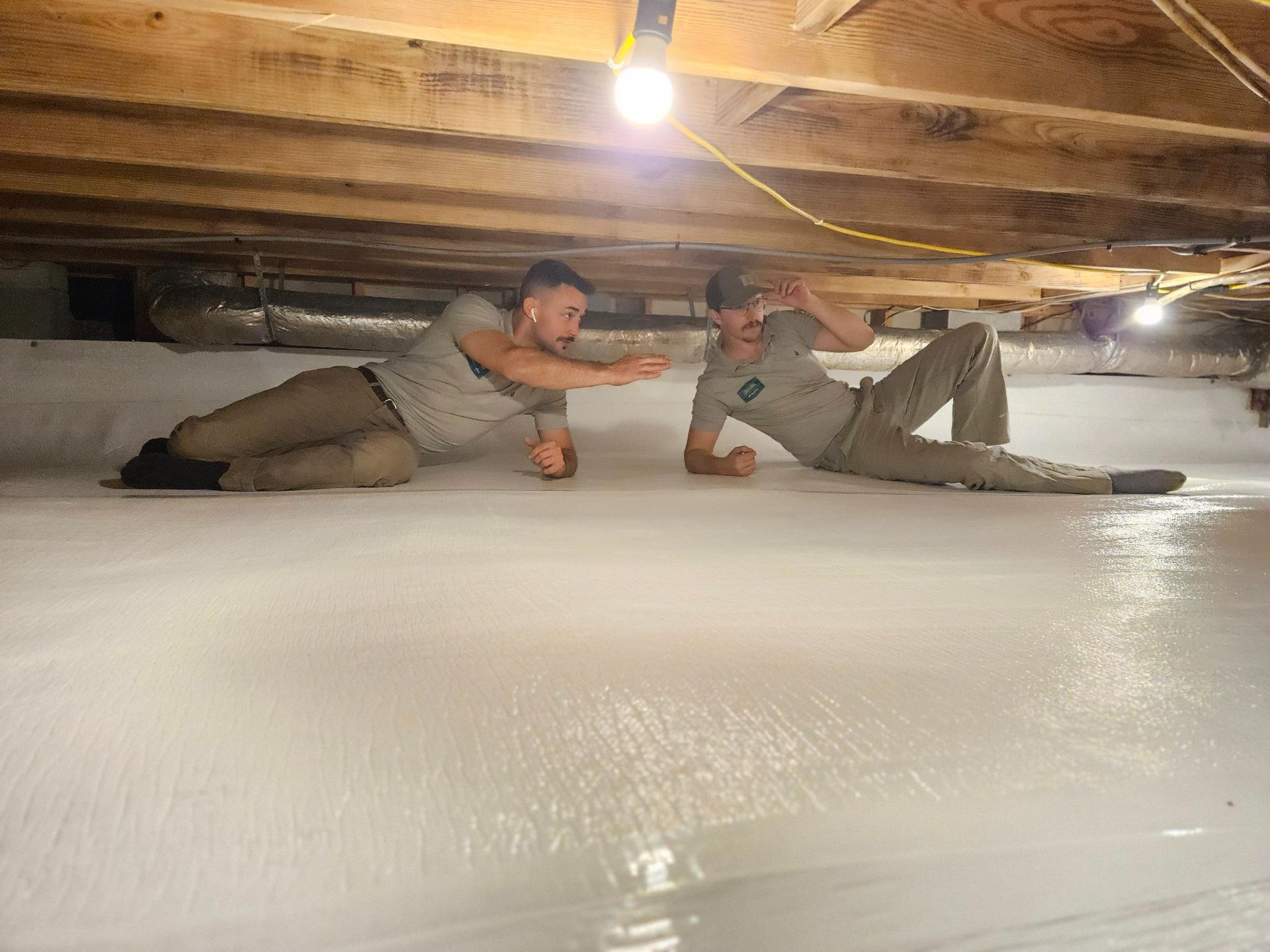 Two men are laying on the floor of a basement.