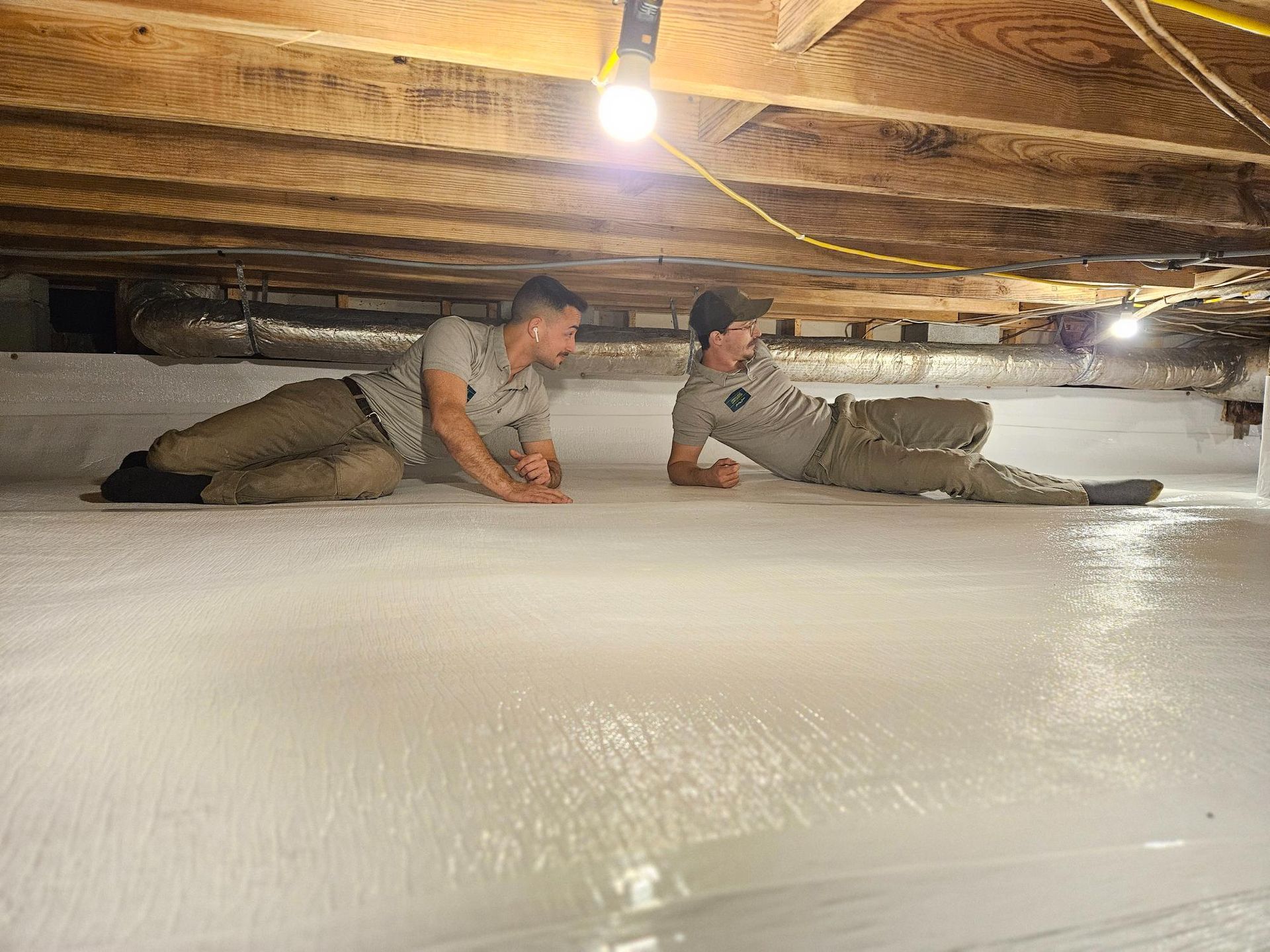 Two men are laying on the floor of a basement.