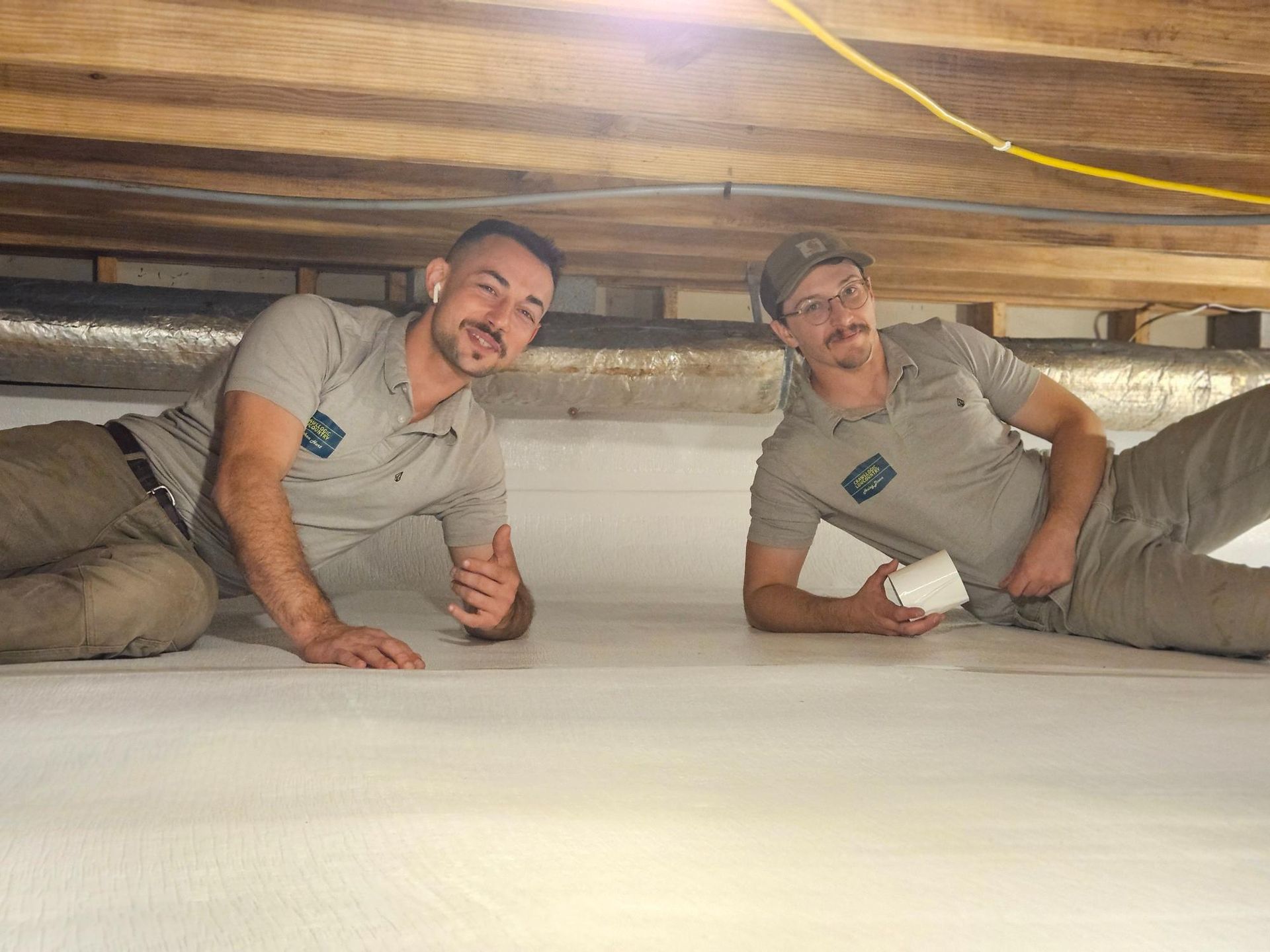 Two men are laying on the floor of a basement.