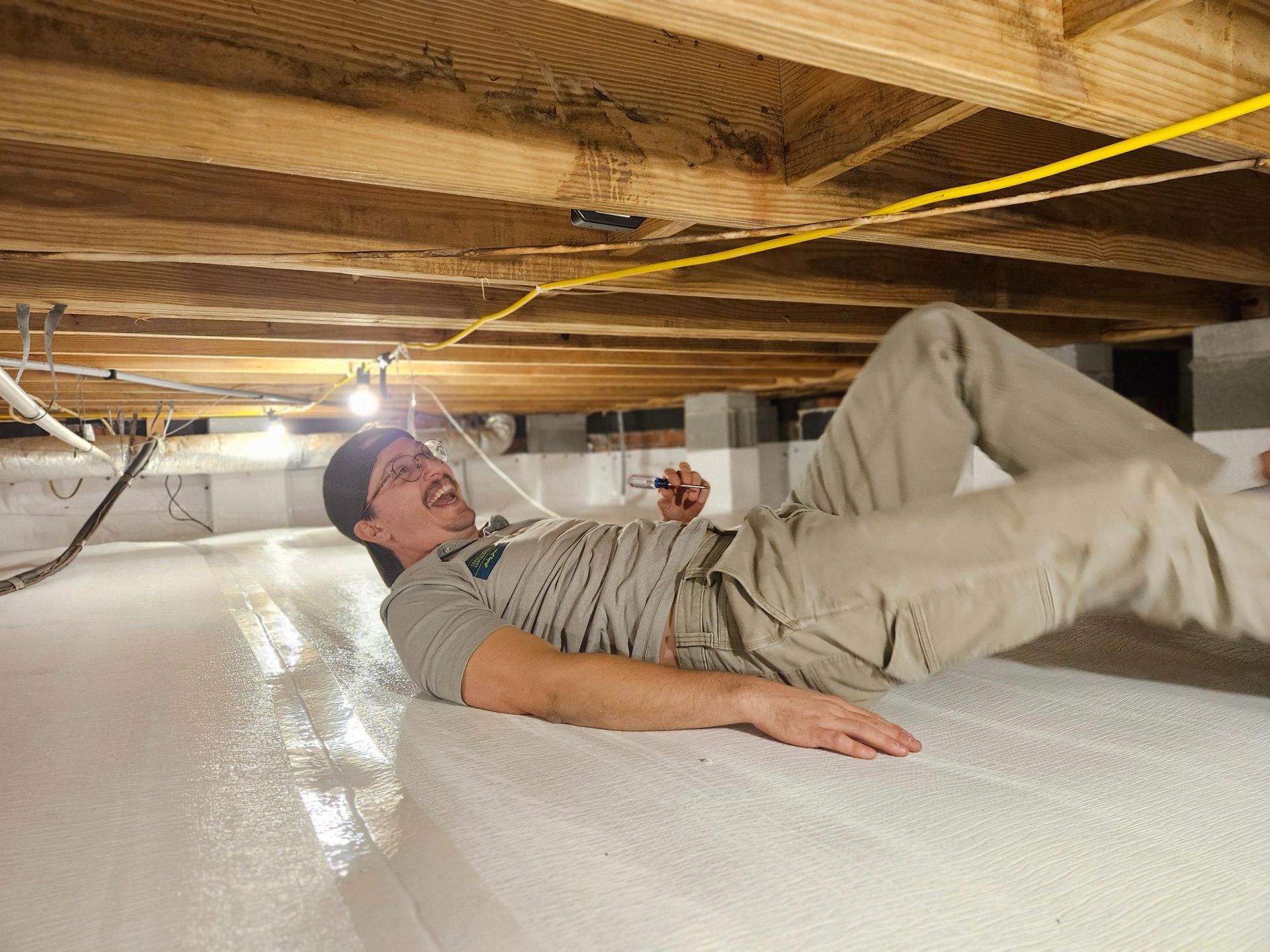 A man is laying on the floor of a basement.