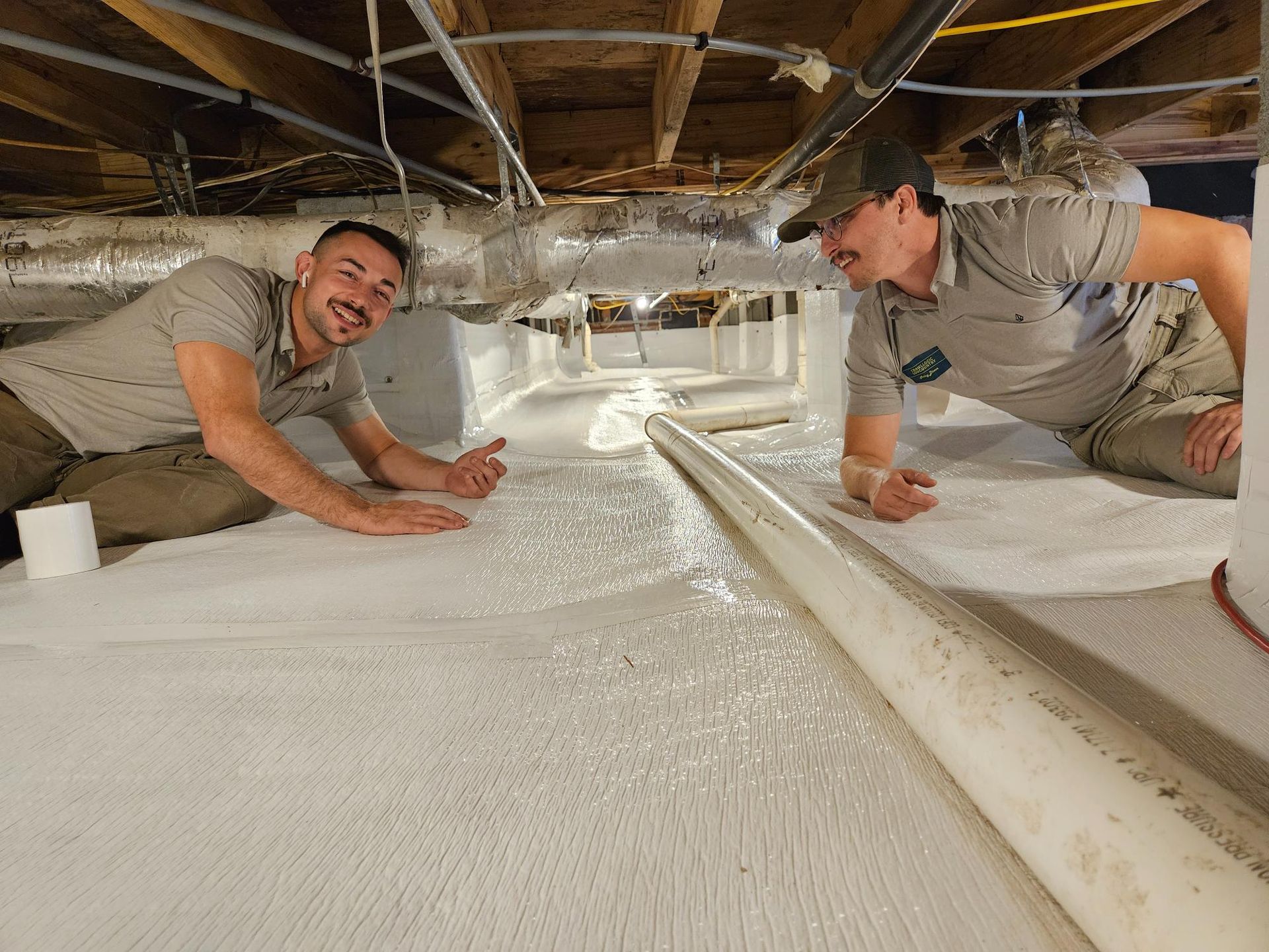 Two men are laying on the floor of a basement.