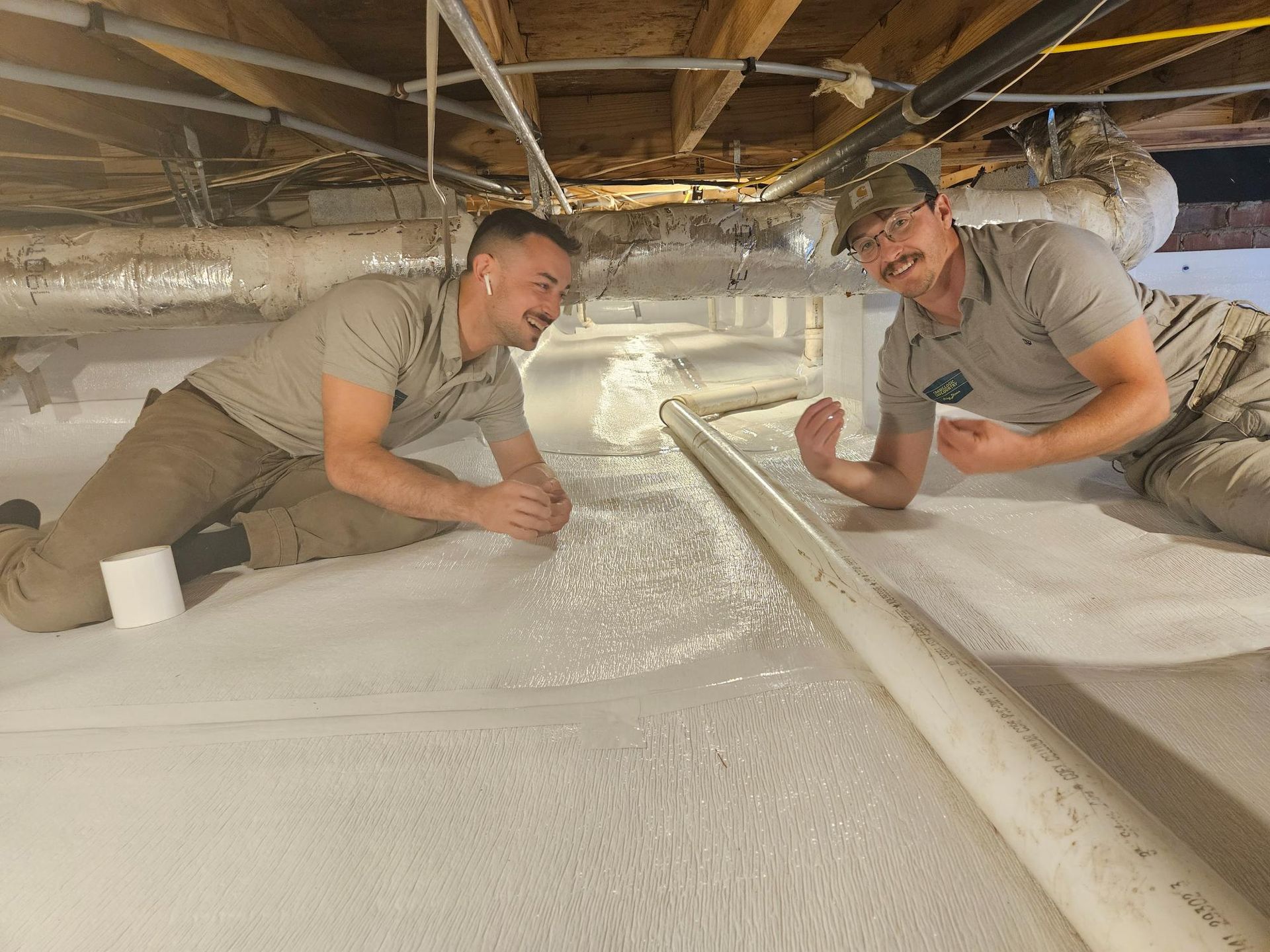 Two men are laying on the floor of a basement.