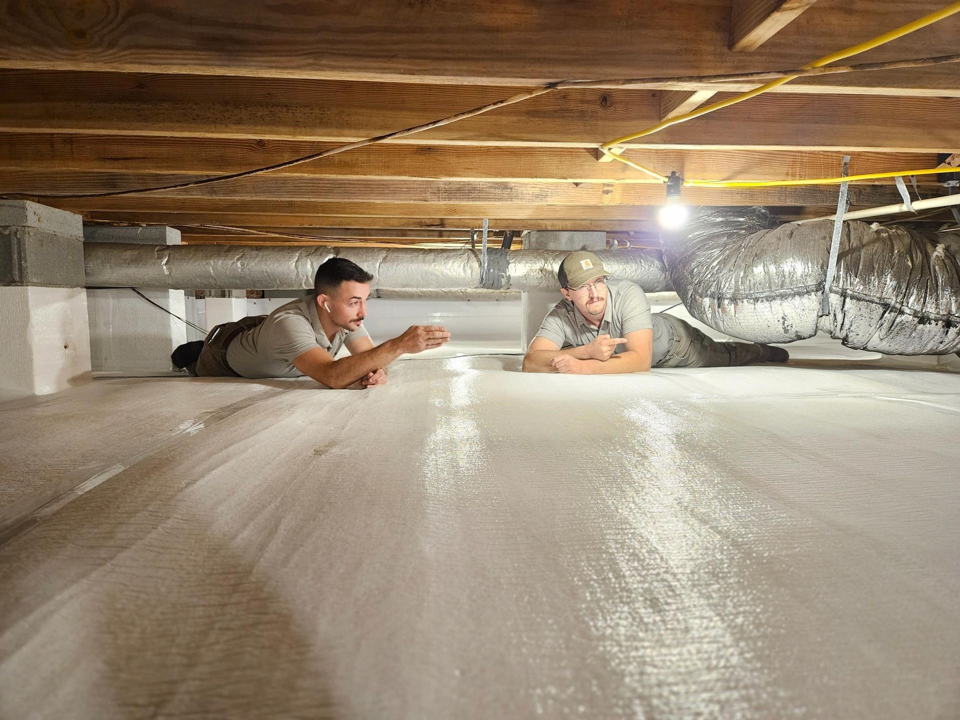 Two men are laying on the floor of a basement.