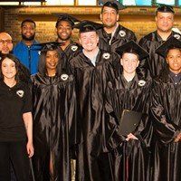 A group of graduates are posing for a picture together.
