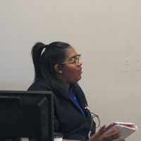 A woman wearing glasses is sitting in front of a computer.