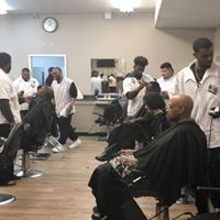 A man is getting his hair cut at a barber shop.