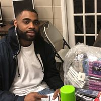 A man with a beard is sitting at a table holding a can of spray paint.
