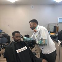 A man is getting his hair cut by a barber in a barber shop.